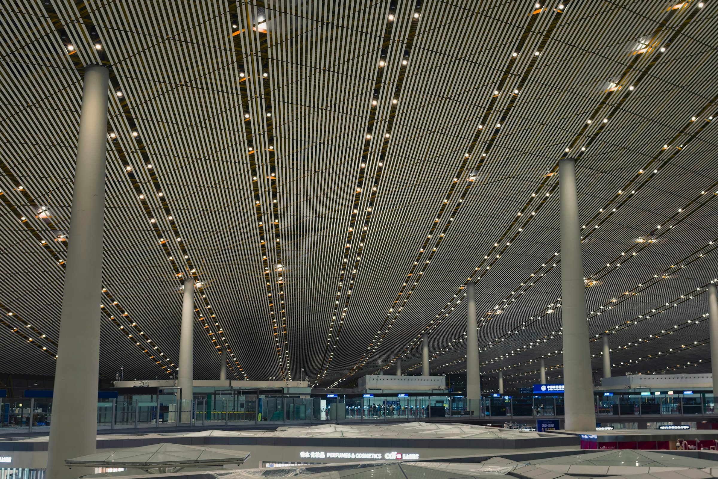 A lit airport terminal ceiling at dusk